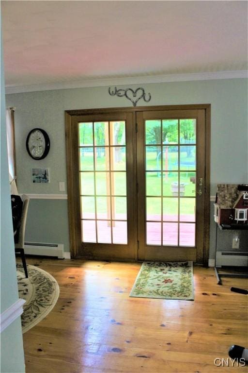 1808 Mulholland Rd, Vienna, NY 13123 - doorway to outside with a baseboard heating unit, ornamental molding, healthy amount of natural light, and light wood-type flooring
