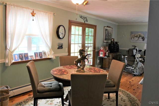 1808 Mulholland Rd, Vienna, NY 13123 - dining area with healthy amount of natural light, wood finished floors, ornamental molding, a baseboard heating unit, and a baseboard radiator