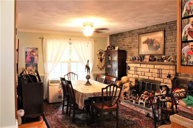 1808 Mulholland Rd, Vienna, NY 13123 - dining area with ceiling fan, wood finished floors, crown molding, and a fireplace