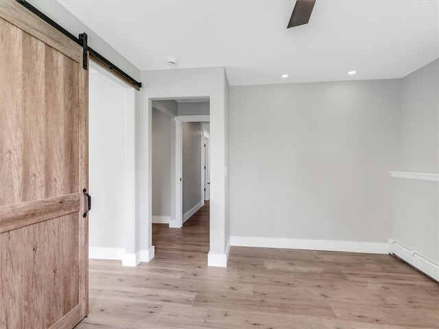 1333 Wayneport Rd, Macedon, NY 14502 - unfurnished bedroom with a barn door, a baseboard heating unit, light wood-style floors, recessed lighting, and a ceiling fan