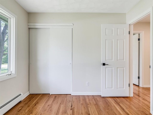 1333 Wayneport Rd, Macedon, NY 14502 - unfurnished bedroom with baseboard heating, light wood-style floors, and a closet