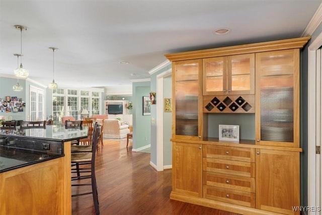 117 Halwill Dr, Amherst, NY 14226 - kitchen with crown molding, dark wood-style flooring, dark countertops, hanging light fixtures, and glass insert cabinets