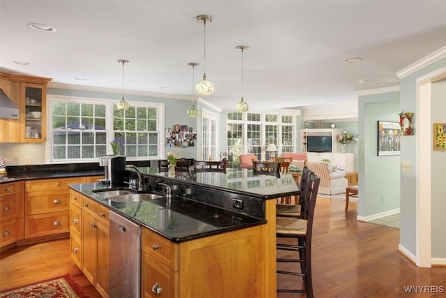 117 Halwill Dr, Amherst, NY 14226 - kitchen featuring stainless steel dishwasher, a breakfast bar area, ornamental molding, an island with sink, and light wood-style floors