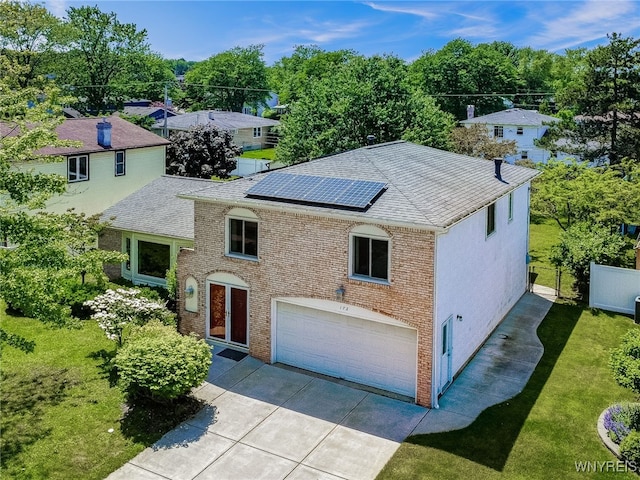 172 Shetland Dr, Amherst, NY 14221 - traditional-style house featuring a garage, concrete driveway, solar panels, and a shingled roof