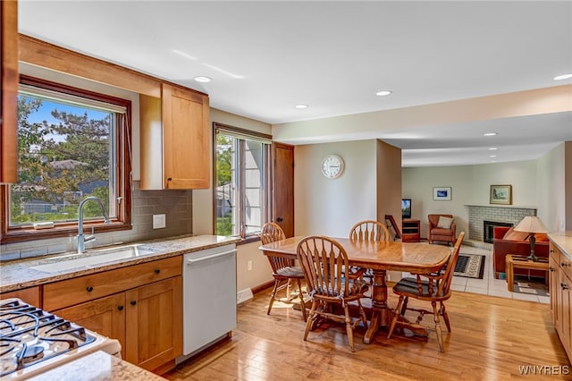 172 Shetland Dr, Amherst, NY 14221 - kitchen featuring dishwashing machine, light wood finished floors, tasteful backsplash, a brick fireplace, and recessed lighting