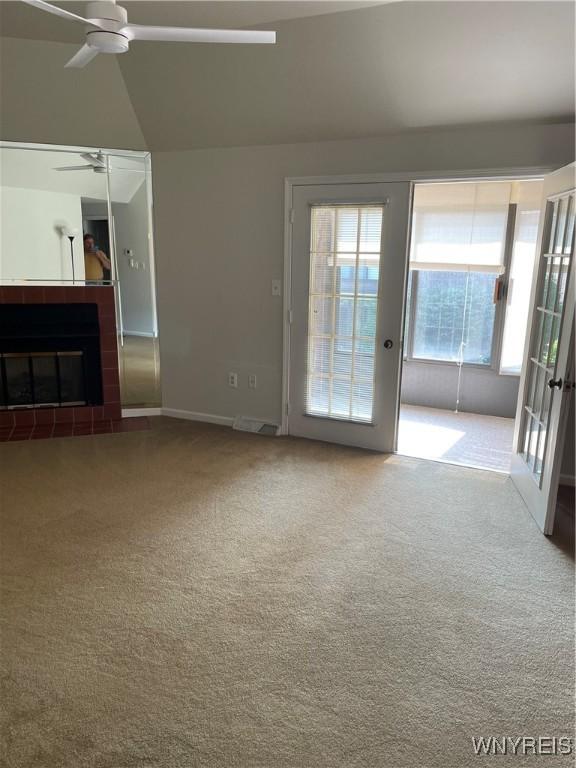 138 Charter Oaks Dr Unit B, Amherst, NY 14228 - unfurnished living room with a ceiling fan, carpet, french doors, a fireplace with flush hearth, and vaulted ceiling
