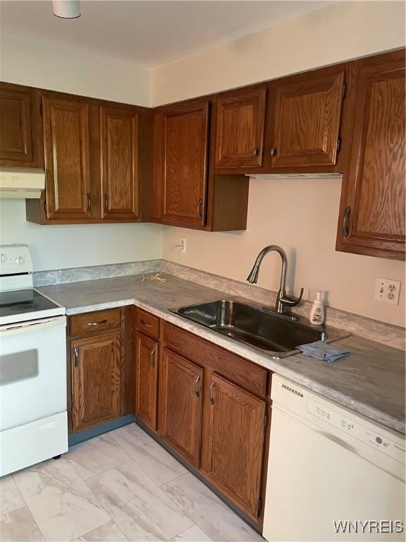 138 Charter Oaks Dr Unit B, Amherst, NY 14228 - kitchen featuring white appliances, premium range hood, light marble finish flooring, light countertops, and brown cabinets