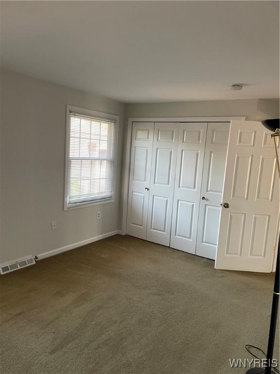 138 Charter Oaks Dr Unit B, Amherst, NY 14228 - unfurnished bedroom featuring dark colored carpet and a closet