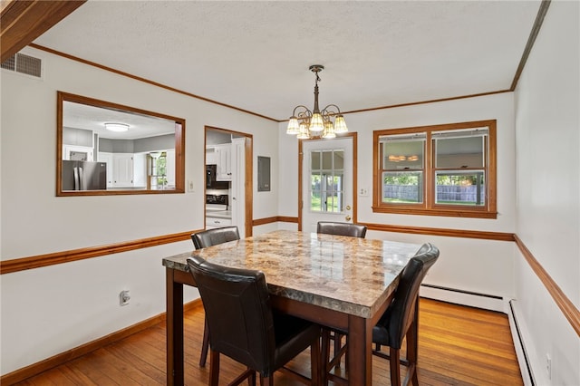 1372 Canandaigua Rd, Macedon, NY 14502 - dining space featuring a baseboard heating unit, hardwood / wood-style floors, crown molding, a chandelier, and a textured ceiling