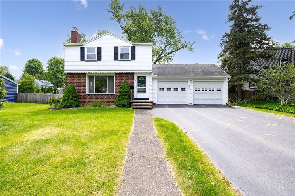 240 Yarmouth Rd, Rochester, NY 14610 - colonial inspired home with an attached garage, a chimney, driveway, and brick siding