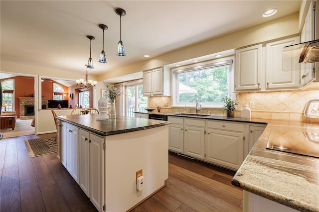 100 Broadmoor Trl, Perinton, NY 14450 - kitchen with white cabinetry, a fireplace, a kitchen island, dark wood-type flooring, and recessed lighting