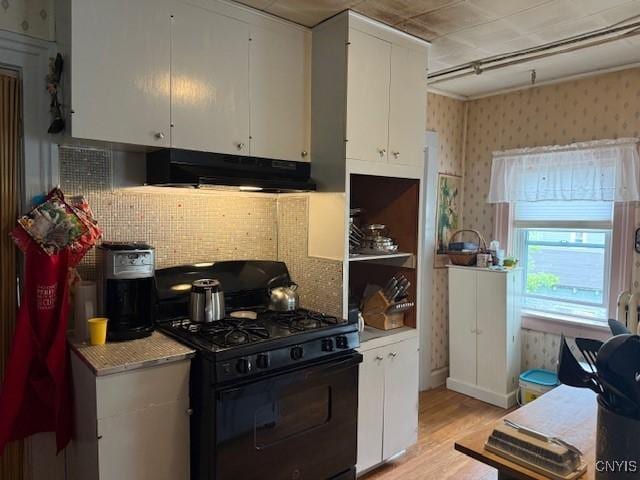 213 N Madison St, Rome-Inside, NY 13440 - kitchen featuring gas stove, under cabinet range hood, light wood-style floors, white cabinets, and backsplash