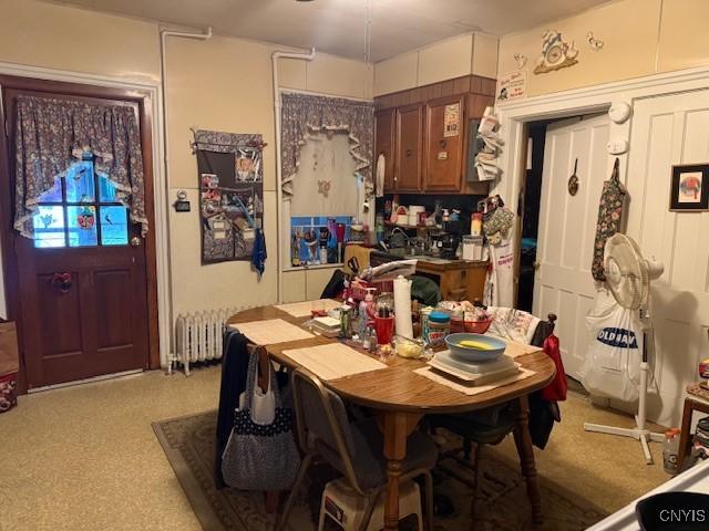 213 N Madison St, Rome-Inside, NY 13440 - dining room featuring radiator heating unit and light colored carpet
