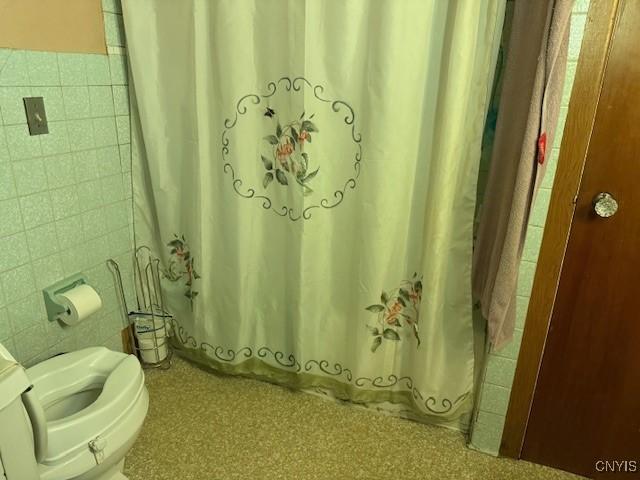 213 N Madison St, Rome-Inside, NY 13440 - bathroom featuring tile walls, shower / tub combo, and wainscoting
