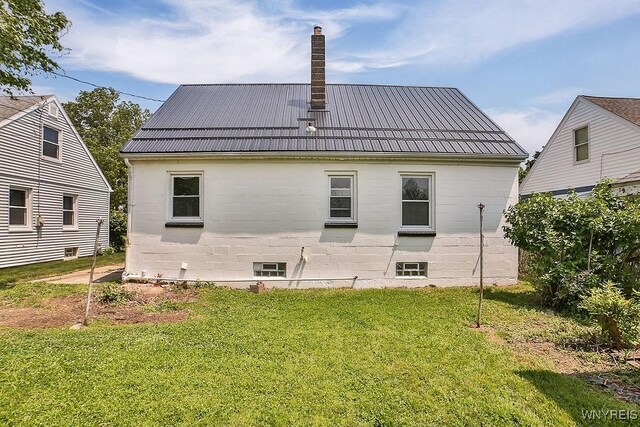 331 S Shore Blvd, Lackawanna, NY 14218 - back of house with a chimney, a yard, and a metal roof