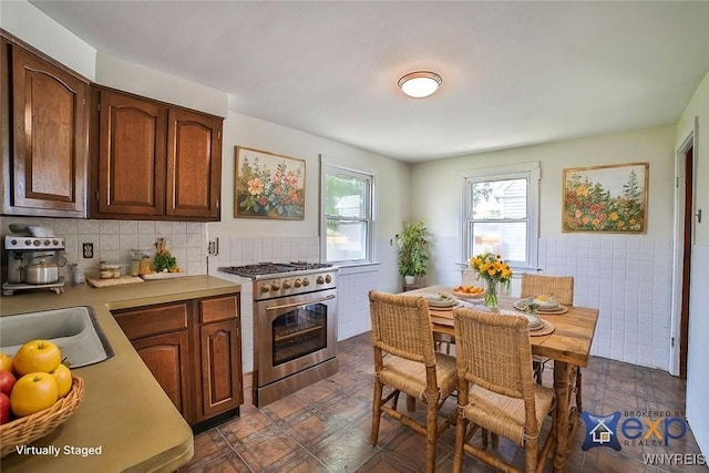 331 S Shore Blvd, Lackawanna, NY 14218 - kitchen with high end stove, light countertops, tile walls, dark flooring, and a wainscoted wall