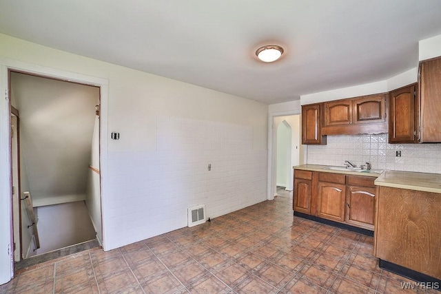 331 S Shore Blvd, Lackawanna, NY 14218 - kitchen featuring light countertops, brown cabinetry, and decorative backsplash