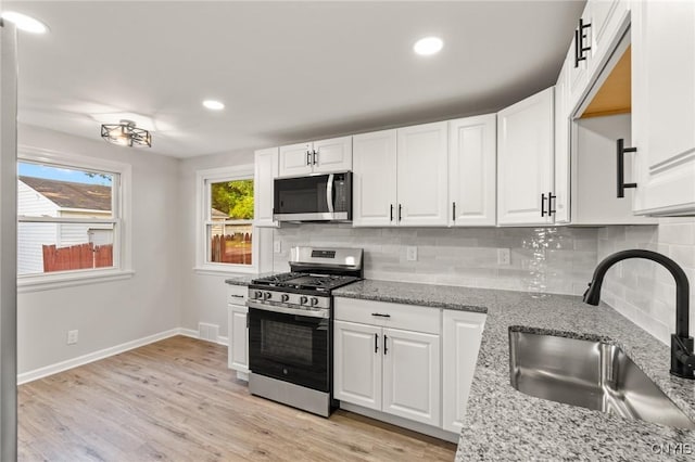 331 Darlington Rd, Syracuse, NY 13208 - kitchen featuring appliances with stainless steel finishes, backsplash, white cabinets, recessed lighting, and light wood-style floors