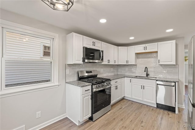 331 Darlington Rd, Syracuse, NY 13208 - kitchen with appliances with stainless steel finishes, white cabinets, light stone countertops, light wood-type flooring, and decorative backsplash