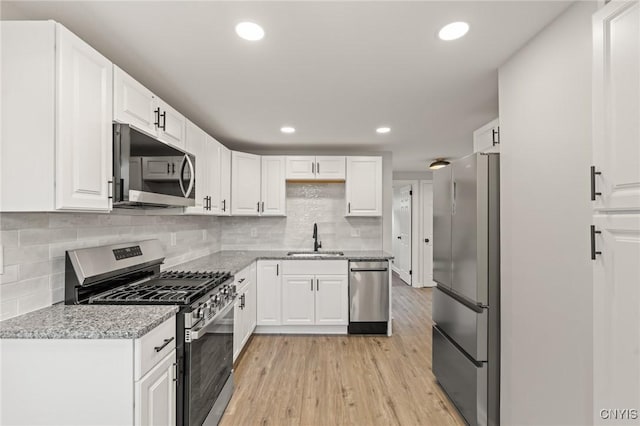 331 Darlington Rd, Syracuse, NY 13208 - kitchen with appliances with stainless steel finishes, light wood-style flooring, white cabinetry, light stone countertops, and recessed lighting