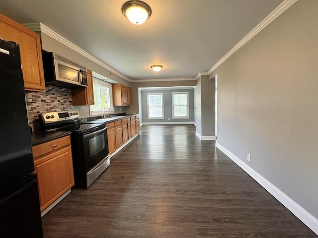 207 Morrow St, Elmira-City, NY 14904 - kitchen featuring appliances with stainless steel finishes, dark countertops, ornamental molding, dark wood-style flooring, and backsplash