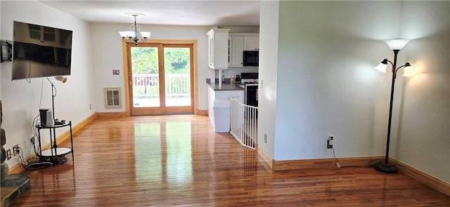 527 Harper Rd, Harpersfield, NY 13786 - kitchen featuring black microwave, light wood-style flooring, white cabinets, a chandelier, and dark countertops