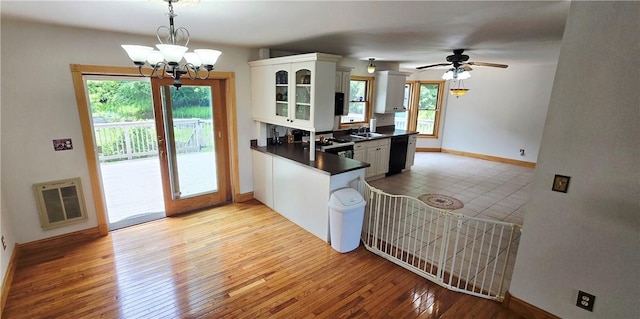 527 Harper Rd, Harpersfield, NY 13786 - kitchen with dark countertops, dishwasher, light wood-type flooring, a chandelier, and white cabinetry