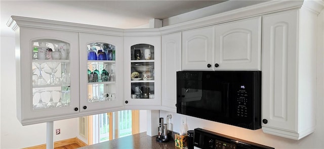 527 Harper Rd, Harpersfield, NY 13786 - kitchen view of black microwave, white cabinetry, and glass insert cabinets