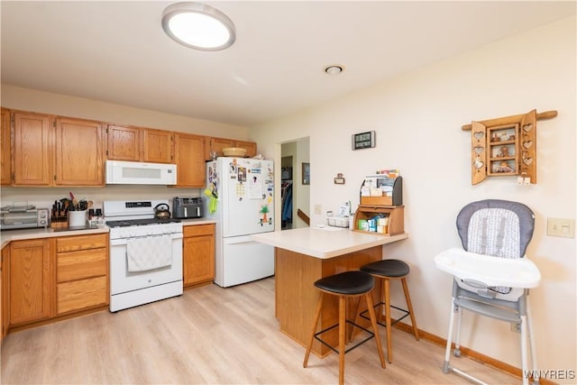 7727 Dewitt Rd, Pike, NY 14024 - kitchen featuring white appliances, a kitchen bar, a peninsula, light countertops, and light wood finished floors