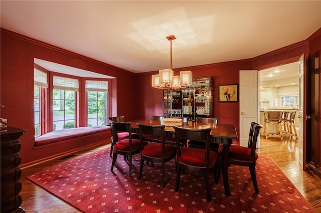 7974 Oak Brook Cir, Pittsford, NY 14534 - dining room featuring crown molding, wood finished floors, and a chandelier