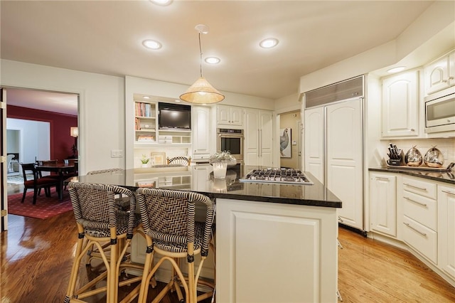 7974 Oak Brook Cir, Pittsford, NY 14534 - kitchen featuring built in appliances, light wood-style flooring, a kitchen bar, white cabinetry, and recessed lighting