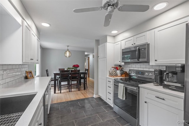 125 Huntshill Rd, Geddes, NY 13209 - kitchen featuring stainless steel appliances, white cabinetry, backsplash, recessed lighting, and light countertops