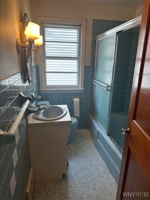 715 83rd St, Niagara Falls, NY 14304 - full bathroom with tile patterned flooring, vanity, shower / bath combination with glass door, and tile walls