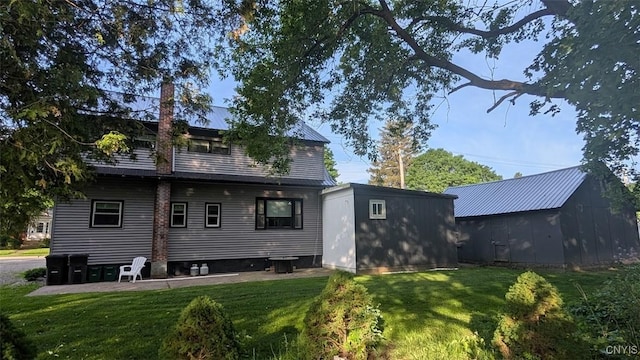 53 Utica St, Hamilton, NY 13346 - rear view of house with a lawn, an outdoor structure, and a chimney