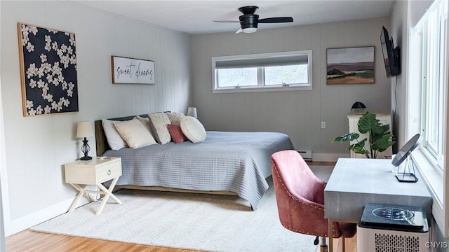 53 Utica St, Hamilton, NY 13346 - bedroom featuring wood finished floors, a baseboard heating unit, and a ceiling fan