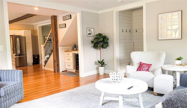 53 Utica St, Hamilton, NY 13346 - living area featuring stairs, light wood-type flooring, wine cooler, a bar, and ornamental molding