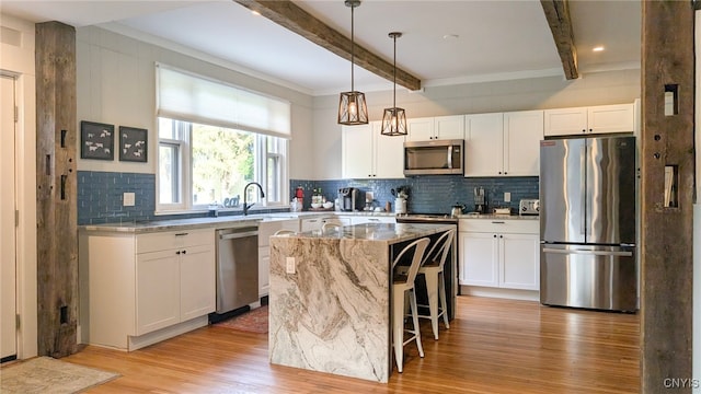 53 Utica St, Hamilton, NY 13346 - kitchen with stainless steel appliances, light wood-style floors, beamed ceiling, light stone counters, and a kitchen island