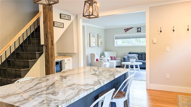 53 Utica St, Hamilton, NY 13346 - kitchen with light wood-type flooring, a kitchen bar, light stone counters, ornamental molding, and wine cooler