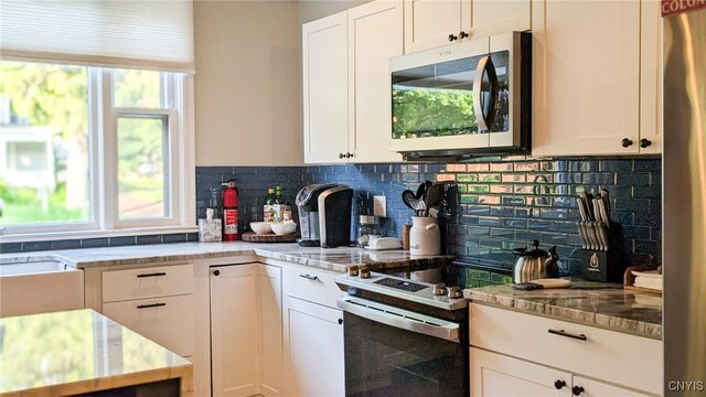53 Utica St, Hamilton, NY 13346 - kitchen with stainless steel appliances, decorative backsplash, light stone countertops, and white cabinetry
