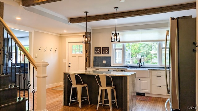 53 Utica St, Hamilton, NY 13346 - kitchen featuring freestanding refrigerator, light wood-style floors, beamed ceiling, white cabinetry, and light stone countertops