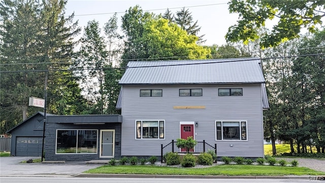 53 Utica St, Hamilton, NY 13346 - view of front of home featuring a garage, a metal roof, view of scattered trees, and a front lawn