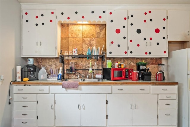 128 Clifford Ave, Rochester, NY 14621 - kitchen with decorative backsplash, light countertops, white cabinets, and freestanding refrigerator