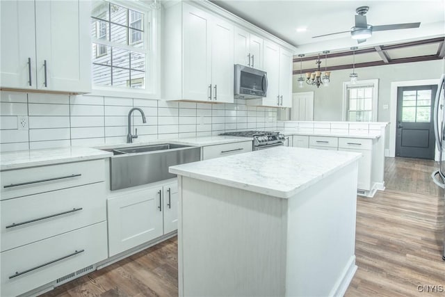 8367 S Main St, Le Ray, NY 13637 - kitchen featuring appliances with stainless steel finishes, a peninsula, light wood-style flooring, ceiling fan, and white cabinets