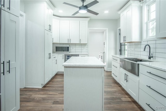 8367 S Main St, Le Ray, NY 13637 - kitchen featuring stainless steel microwave, recessed lighting, decorative backsplash, a ceiling fan, and dark wood-style floors
