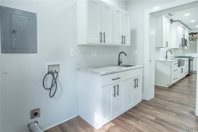 8367 S Main St, Le Ray, NY 13637 - washroom with electric panel, washer hookup, light wood finished floors, cabinet space, and hookup for an electric dryer