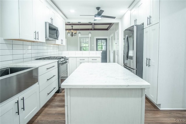 8367 S Main St, Le Ray, NY 13637 - kitchen with stainless steel appliances, a peninsula, dark wood finished floors, tasteful backsplash, and white cabinetry