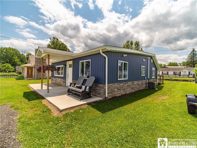 2389 Lakeside Dr, Busti, NY 14710 - back of house featuring a patio, stone siding, and a lawn