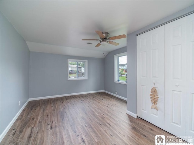 2389 Lakeside Dr, Busti, NY 14710 - unfurnished bedroom with wood finished floors, a closet, ceiling fan, and vaulted ceiling
