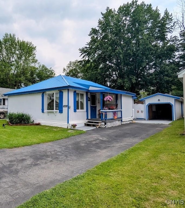 2008 Main St, Vienna, NY 13157 - view of front of home with a garage, an outdoor structure, driveway, and a front lawn