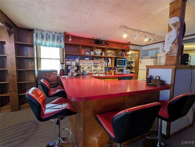 2008 Main St, Vienna, NY 13157 - bar with freestanding refrigerator, stainless steel microwave, a textured ceiling, and rail lighting